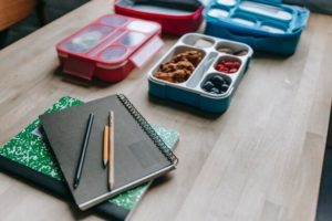 school lunch in bento box along with school supplies