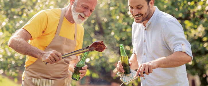 father and son enjoy beers at bbq